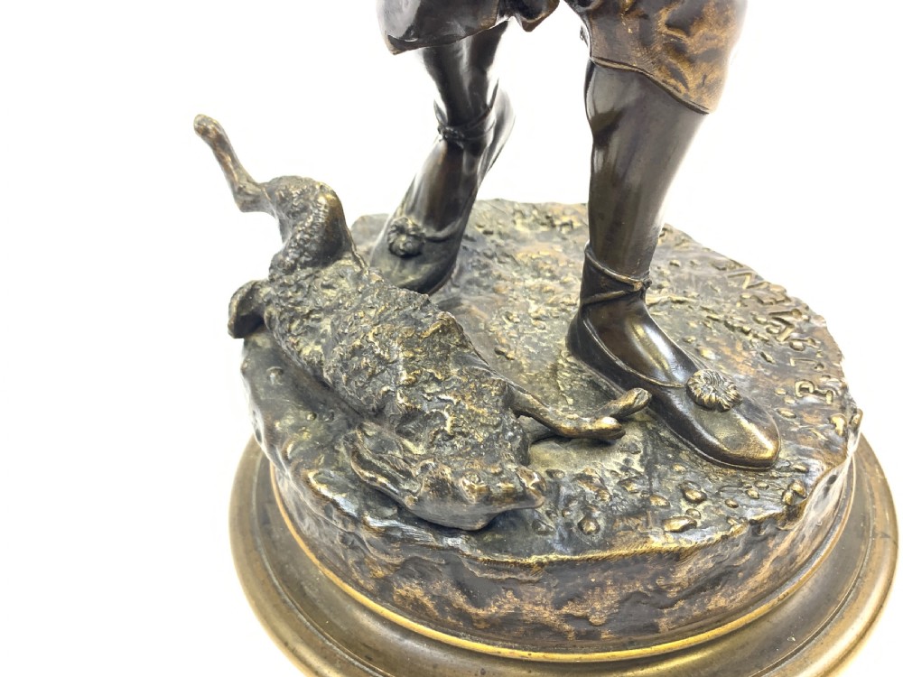 A dark brown patinated bronze sculpture depicting an Arab falconer holding a falcon overhead while standing on a circular base. View IX