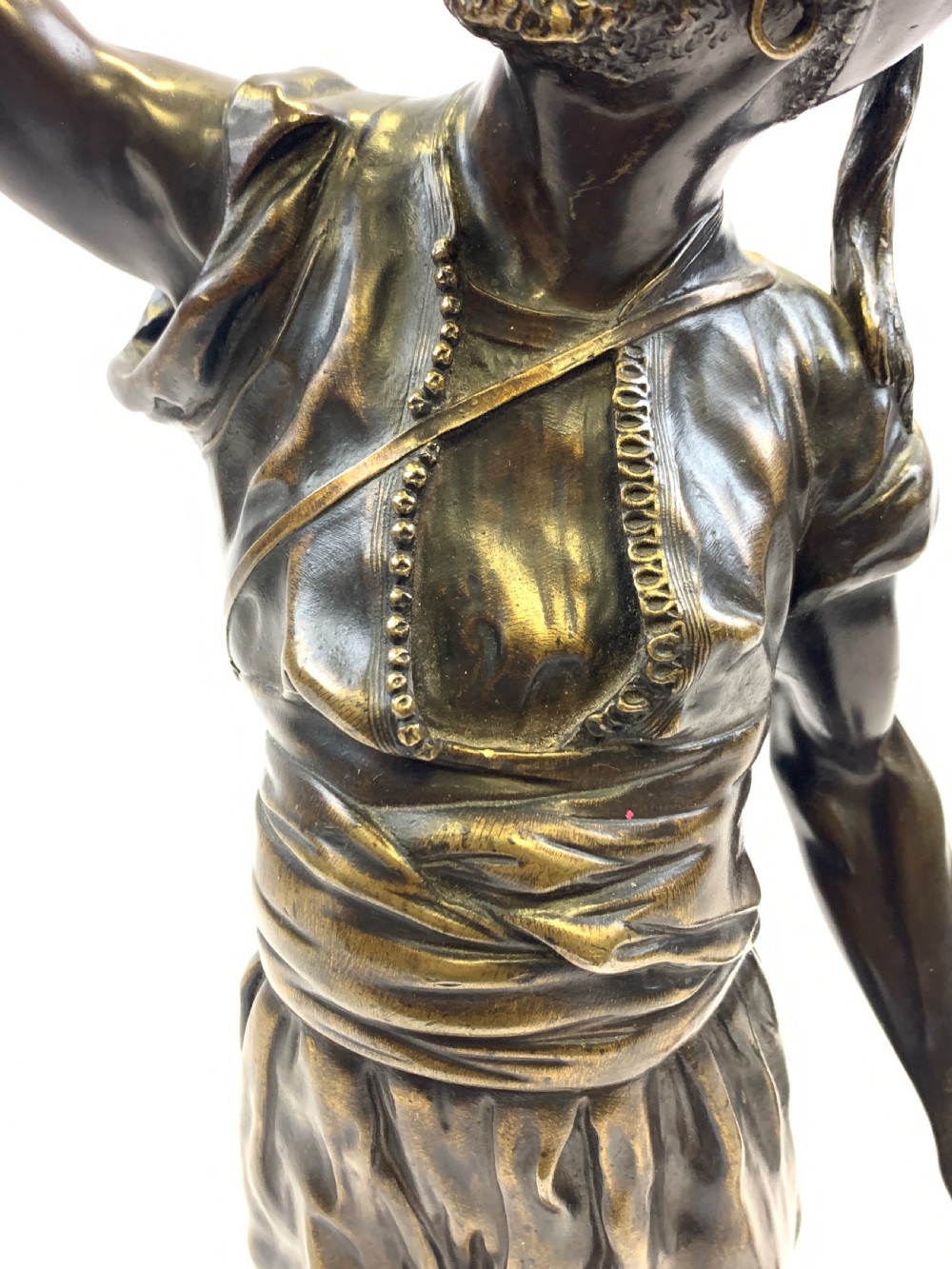 A dark brown patinated bronze sculpture depicting an Arab falconer holding a falcon overhead while standing on a circular base. View XI