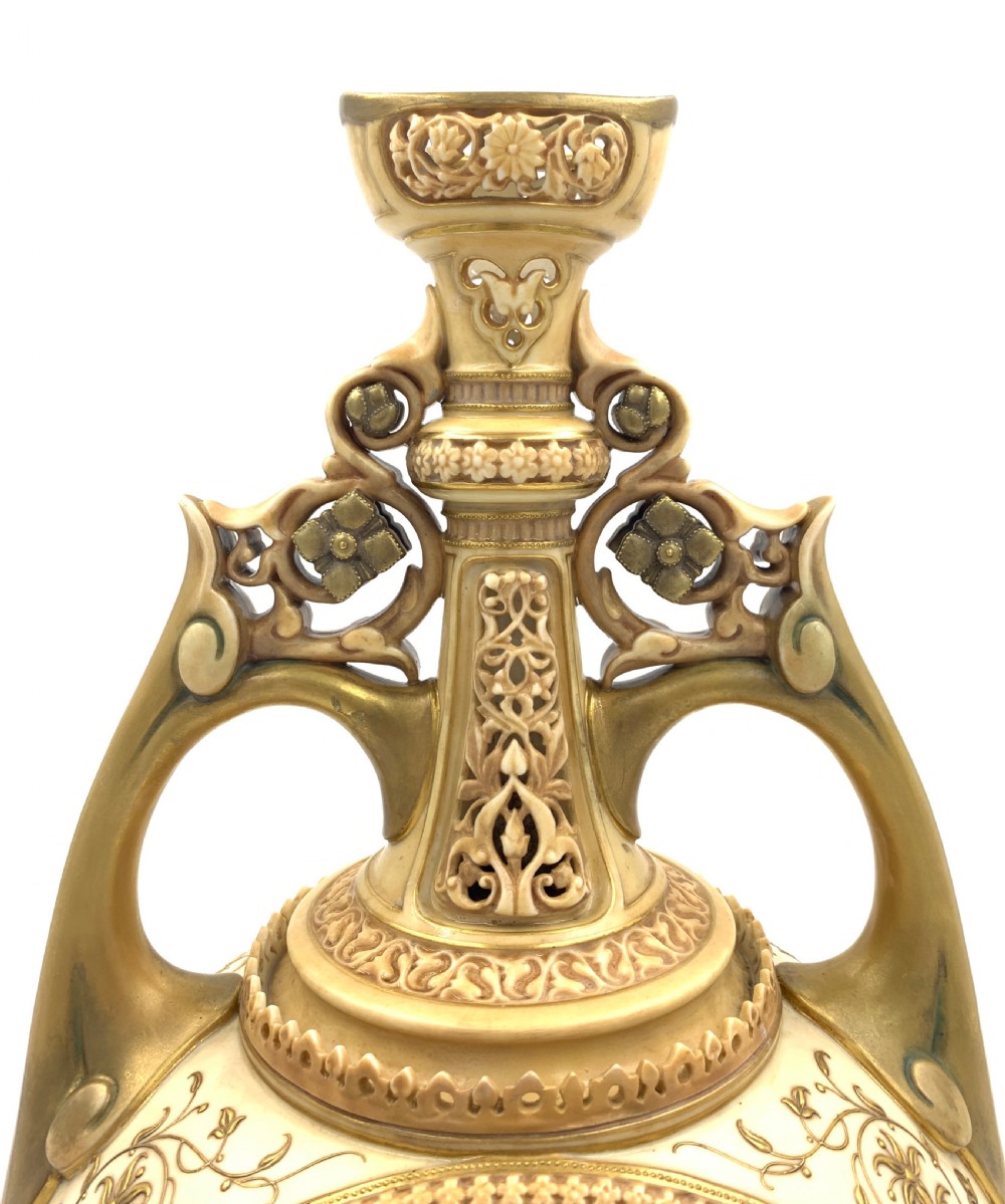 A late 19th-century Royal Worcester porcelain vase featuring twin handles, pierced reticulated panels, gilt accenting, and relief floral decoration on a blush ivory surface. View VII