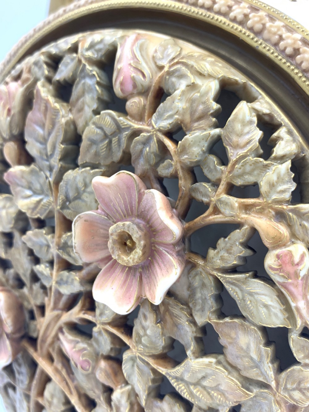 A late 19th-century Royal Worcester porcelain vase featuring twin handles, pierced reticulated panels, gilt accenting, and relief floral decoration on a blush ivory surface. View XI