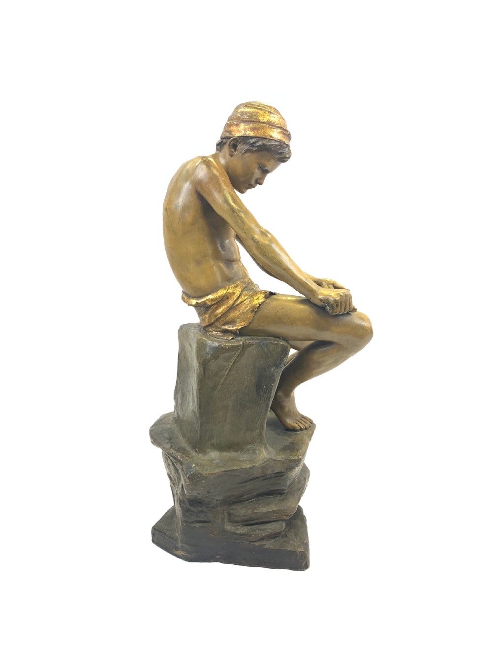A late 19th-century Goldscheider cold-painted terracotta figure depicting a seated boy with a headscarf on a rocky base, finished in a bronzed metallic glaze. View II