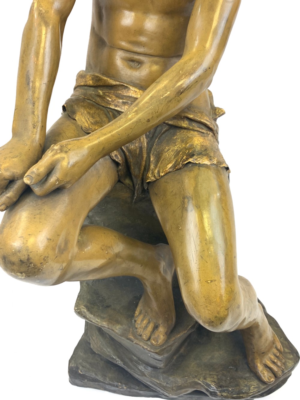 A late 19th-century Goldscheider cold-painted terracotta figure depicting a seated boy with a headscarf on a rocky base, finished in a bronzed metallic glaze. View VI