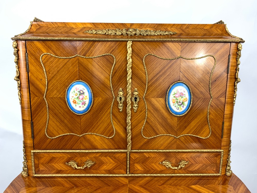 A late 19th-century French kingwood bonheur du jour featuring parquetry veneers, gilt-bronze mounts, oval porcelain plaques, and curved cabriole legs. View V