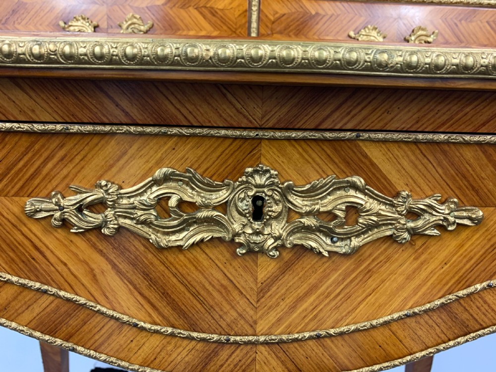 A late 19th-century French kingwood bonheur du jour featuring parquetry veneers, gilt-bronze mounts, oval porcelain plaques, and curved cabriole legs. View X