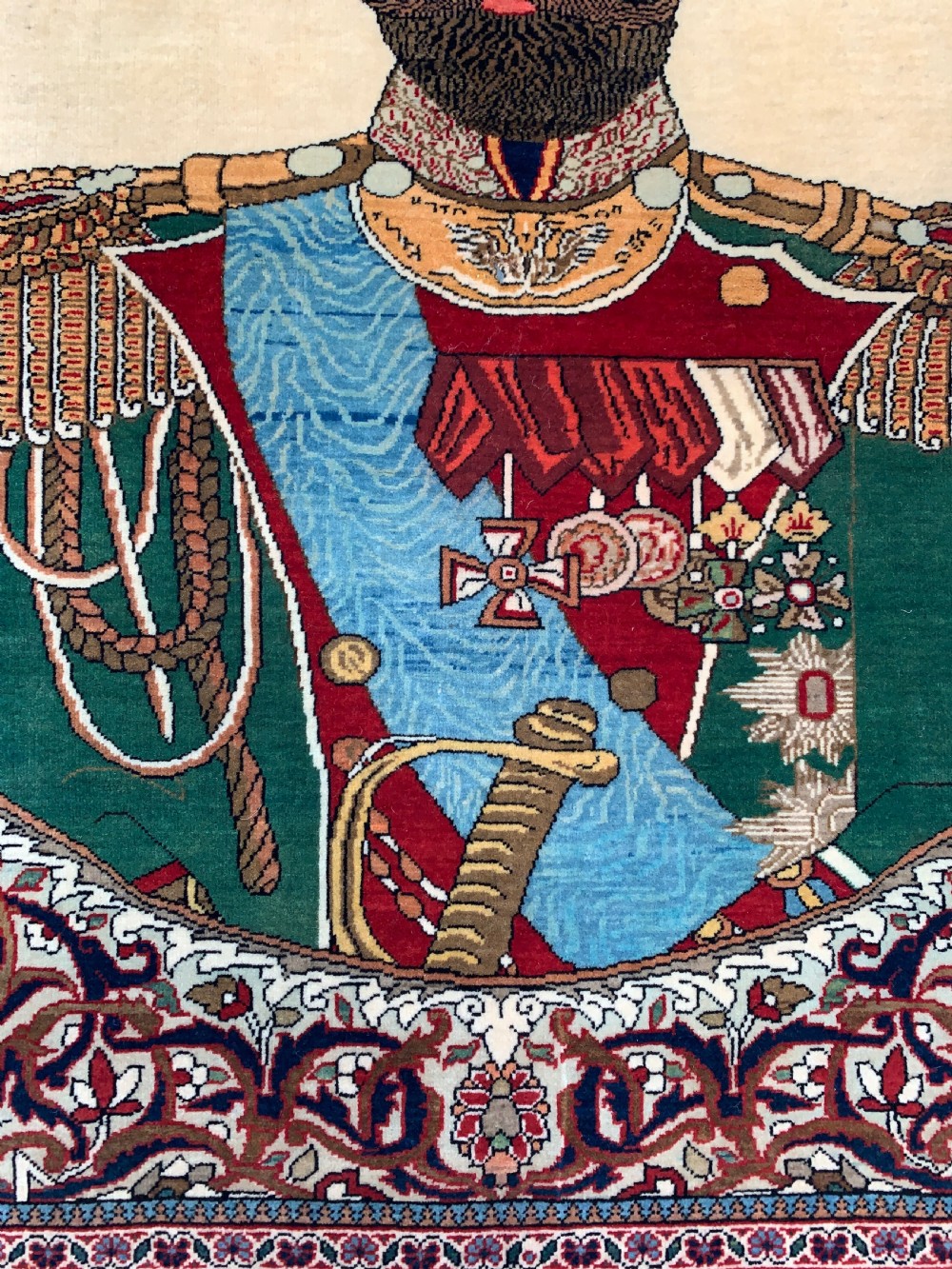 A hand-knotted antique Persian pictorial rug depicting Tsar Nicholas II of Russia in military uniform, framed by a cream archway and a dark red floral border with Persian script. View IV