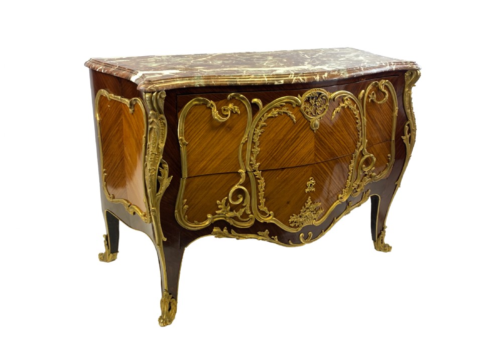 A French Louis XV style bombe commode featuring rich kingwood parquetry veneers, ornate gilt-bronze ormolu mounts, cabriole legs, and a shaped variegated marble top.