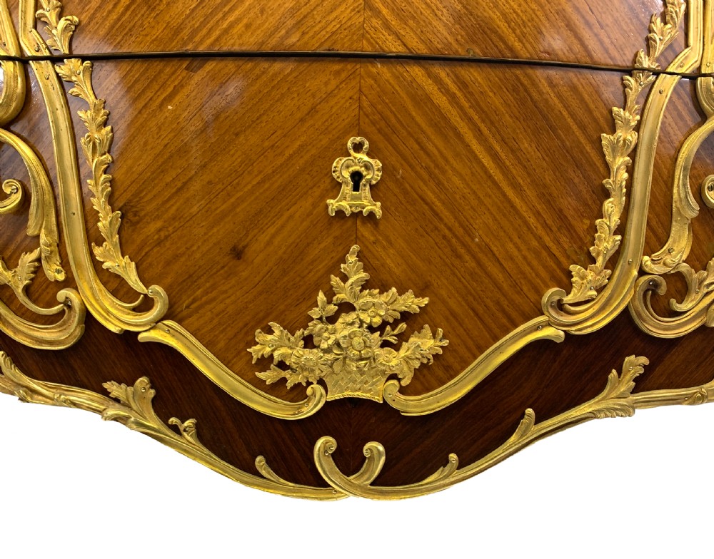 A French Louis XV style bombe commode featuring rich kingwood parquetry veneers, ornate gilt-bronze ormolu mounts, cabriole legs, and a shaped variegated marble top. View IV