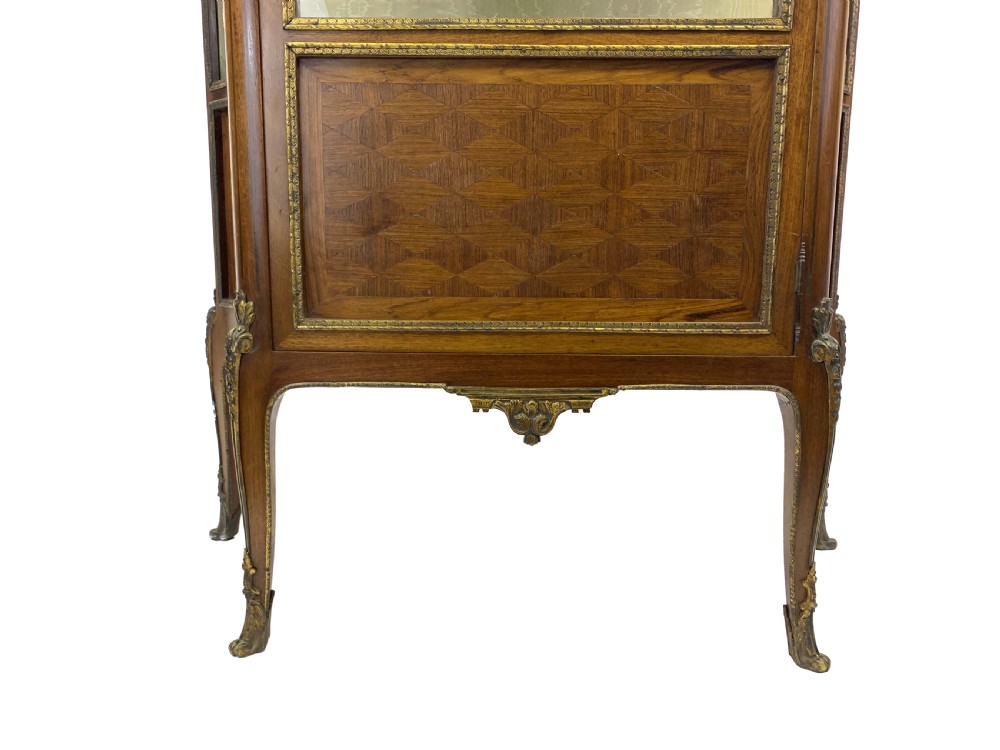 A French Louis XV style glazed vitrine featuring a contoured marble top, gilt-metal mounts, lower parquetry panels, and slender cabriole legs. View VI