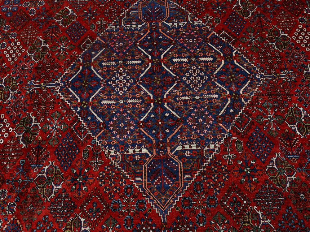 A large hand-knotted Persian Joshagan carpet featuring a central diamond medallion, intricate red geometric field, navy spandrels, and decorative borders. View II