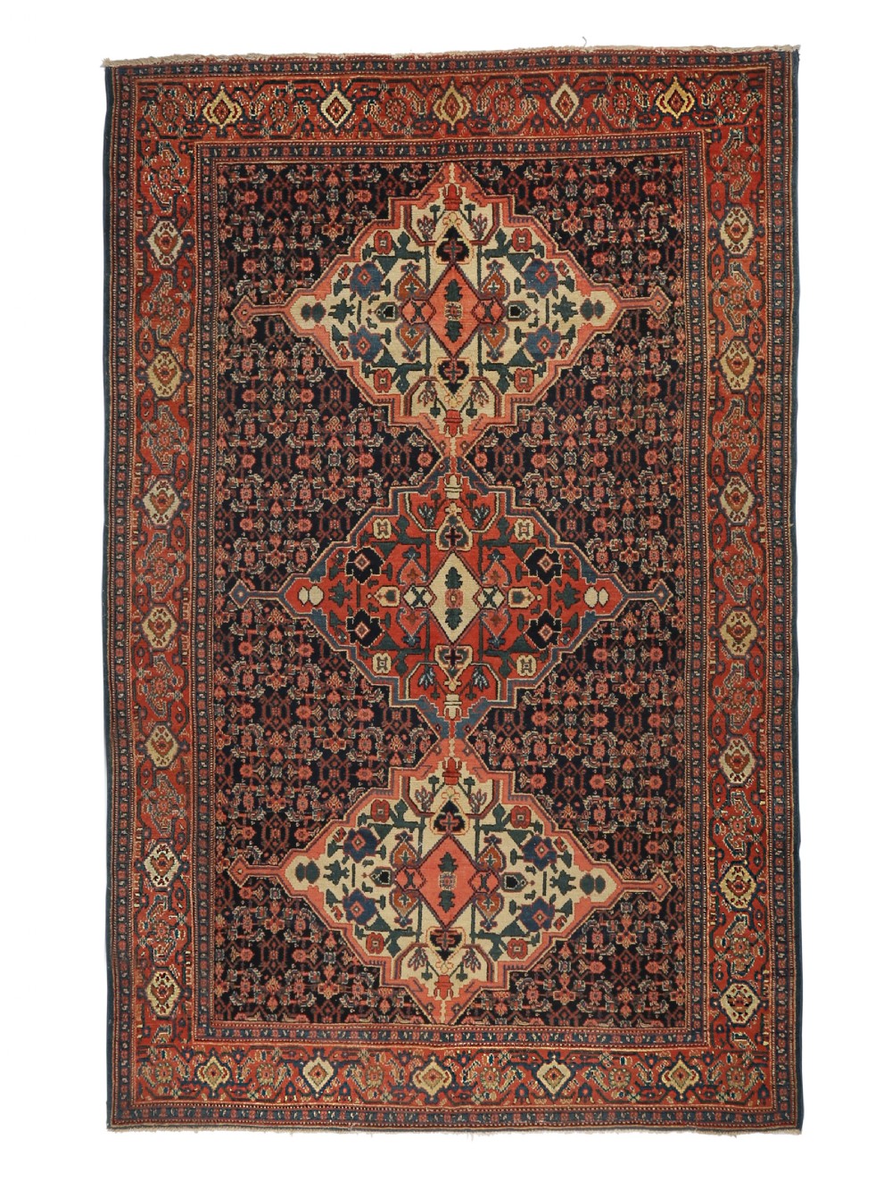 An antique Persian Senneh wool rug featuring three central diamond medallions set over a dark navy field with dense geometric floral motifs framed by a brick red border.
