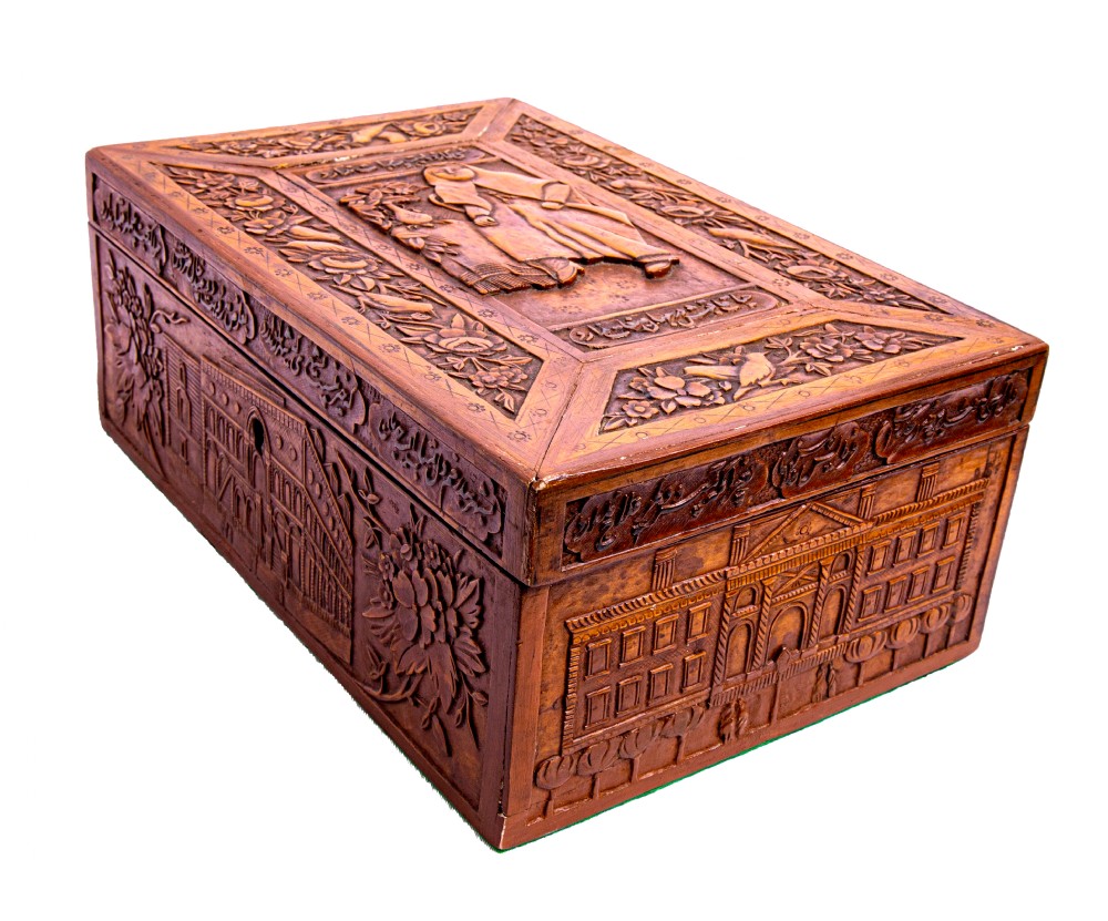 A 19th-century rectangular Qajar Iranian carved wooden casket featuring relief depictions of architectural buildings, figures, and Persian calligraphy.