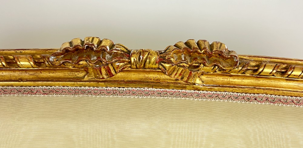 A five-piece 19th-century French Louis XVI style giltwood salon suite featuring a three-seater settee and four matching fauteuil armchairs upholstered in cream fabric. View IV
