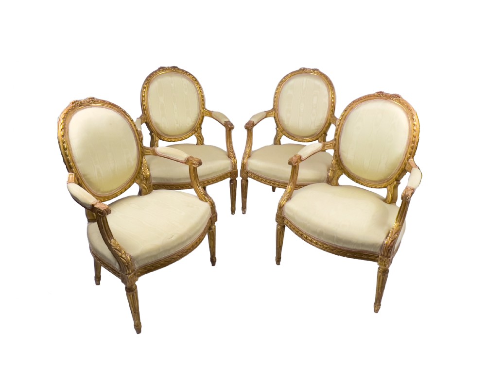 A five-piece 19th-century French Louis XVI style giltwood salon suite featuring a three-seater settee and four matching fauteuil armchairs upholstered in cream fabric. View VI
