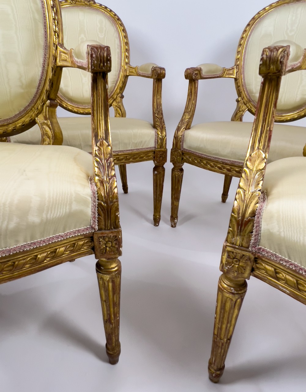A five-piece 19th-century French Louis XVI style giltwood salon suite featuring a three-seater settee and four matching fauteuil armchairs upholstered in cream fabric. View VII