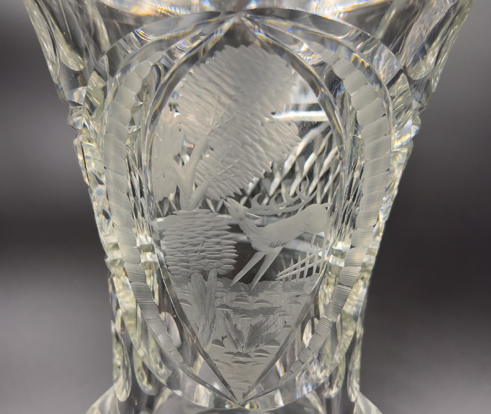 A pair of clear cut glass lidded urns featuring etched woodland motifs and faceted pedestal bases. View III