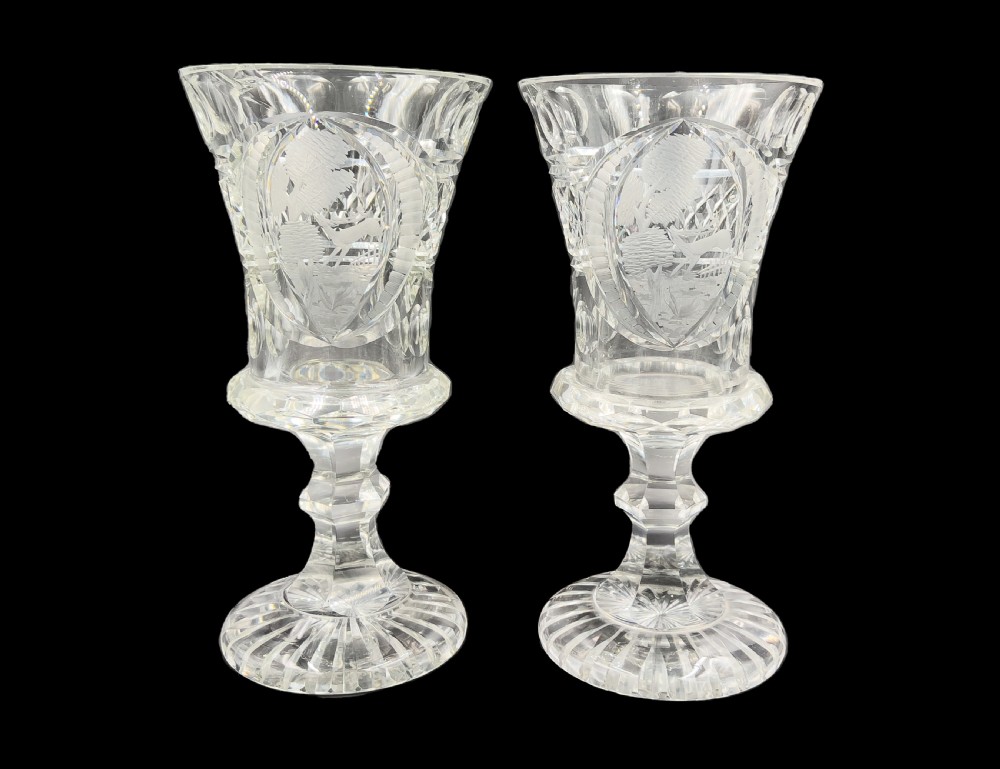 A pair of clear cut glass lidded urns featuring etched woodland motifs and faceted pedestal bases. View VIII