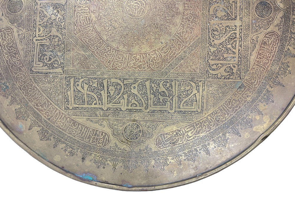 A late 19th-century round centre table featuring an intricately engraved brass top with Arabic calligraphic inscriptions resting on carved wooden barley-twist legs. View VI