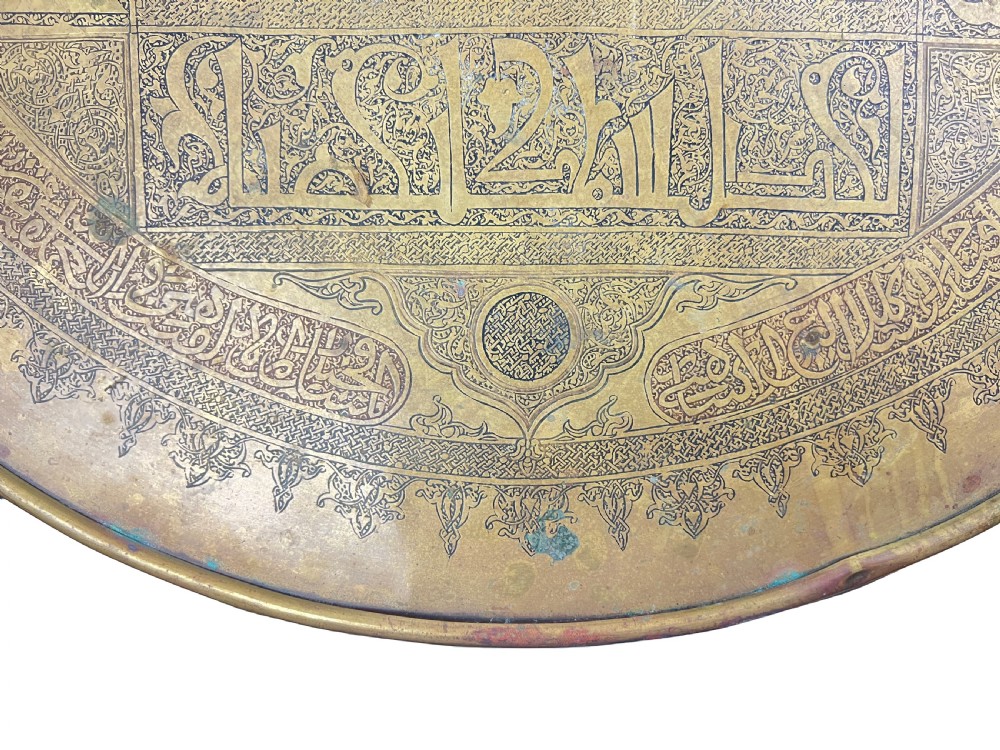 A late 19th-century round centre table featuring an intricately engraved brass top with Arabic calligraphic inscriptions resting on carved wooden barley-twist legs. View VII