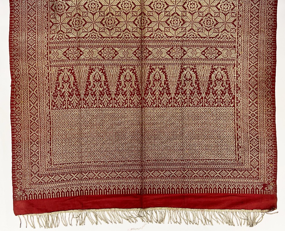 A long rectangular 19th-century Indian textile crafted with red silk and woven gold metallic thread, featuring geometric lattice patterns, decorative borders, and fringed ends. View II