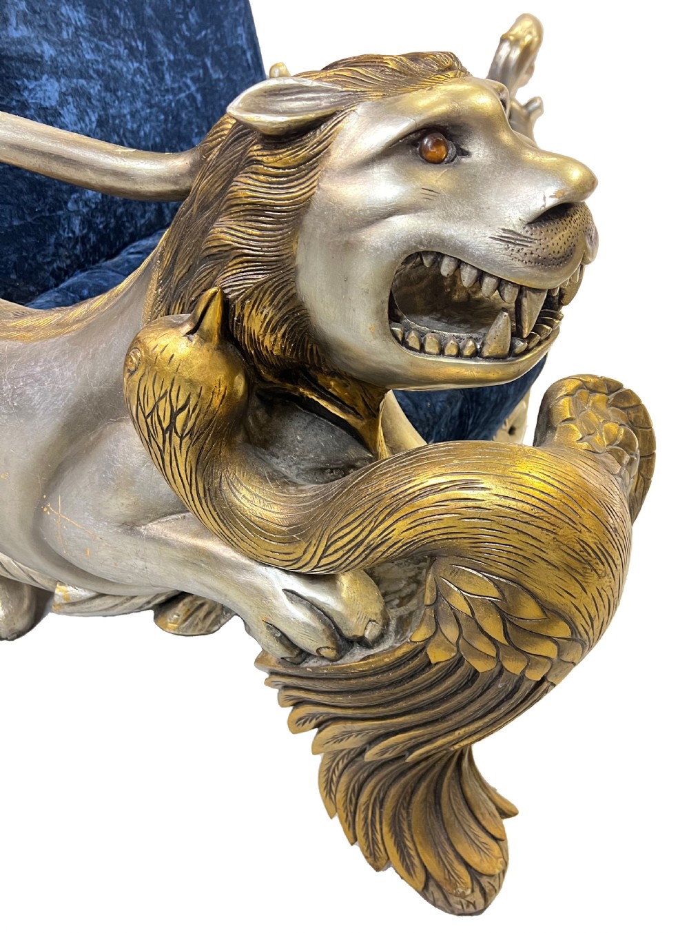 An ornate two-seater sofa featuring deep blue crushed velvet upholstery and a gilded wooden frame carved with a lion on one armrest and branch motifs on the other. View VI