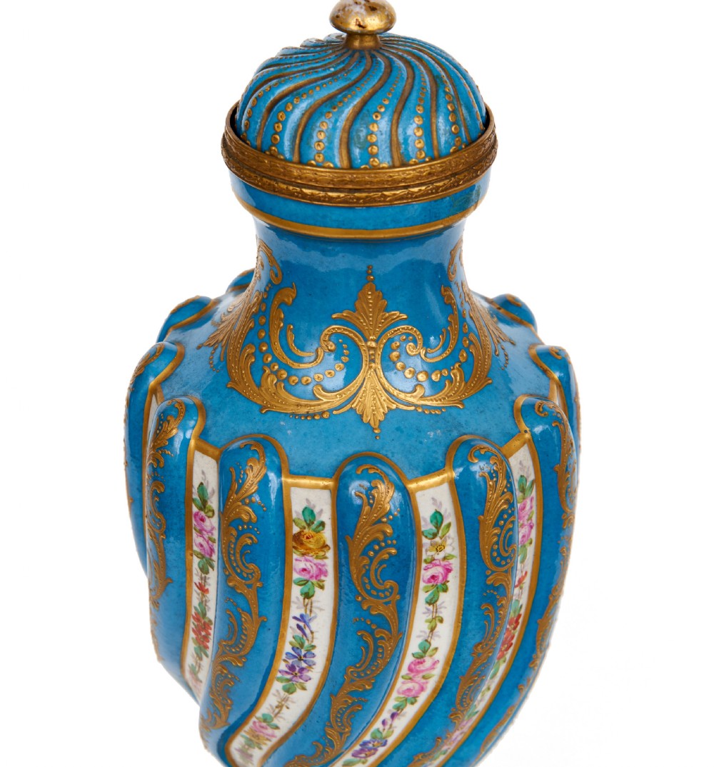 A 19th-century Sevres style sky blue and gilt porcelain vase with a cover, featuring spiralled flutes decorated with floral painted garlands. View VI