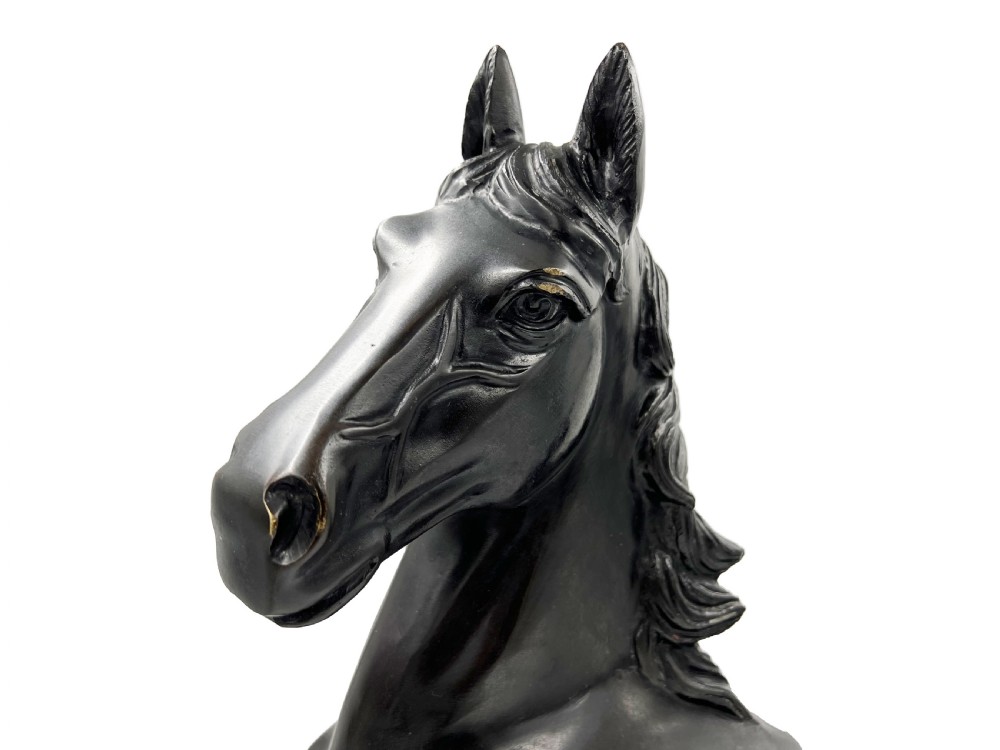 A dark patinated bronze sculpture of a horse depicted with its right front leg raised and head turned slightly forward. View IV
