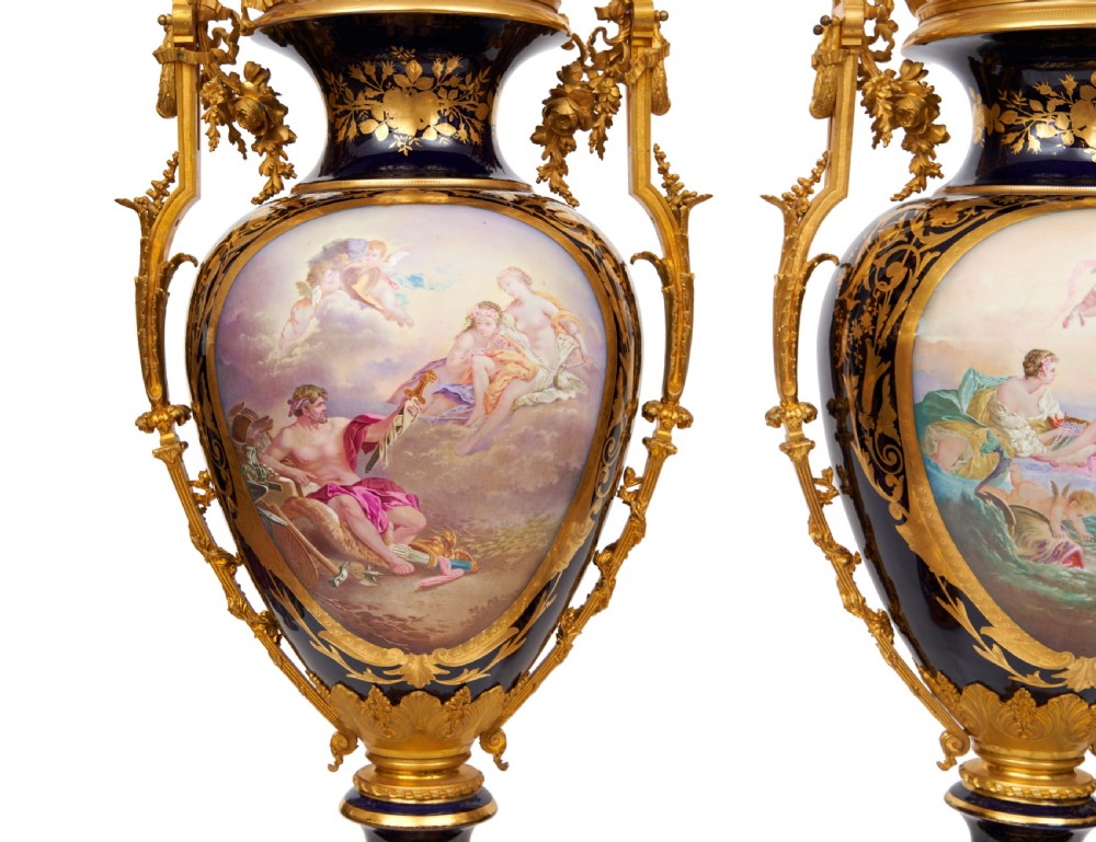 A pair of large French Sevres style cobalt blue porcelain lidded urns featuring hand-painted mythological scenes and elaborate gilded ormolu handles. View IV
