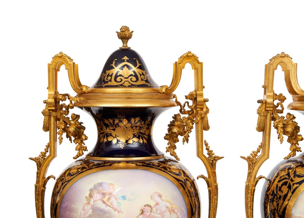 A pair of large French Sevres style cobalt blue porcelain lidded urns featuring hand-painted mythological scenes and elaborate gilded ormolu handles. View VII