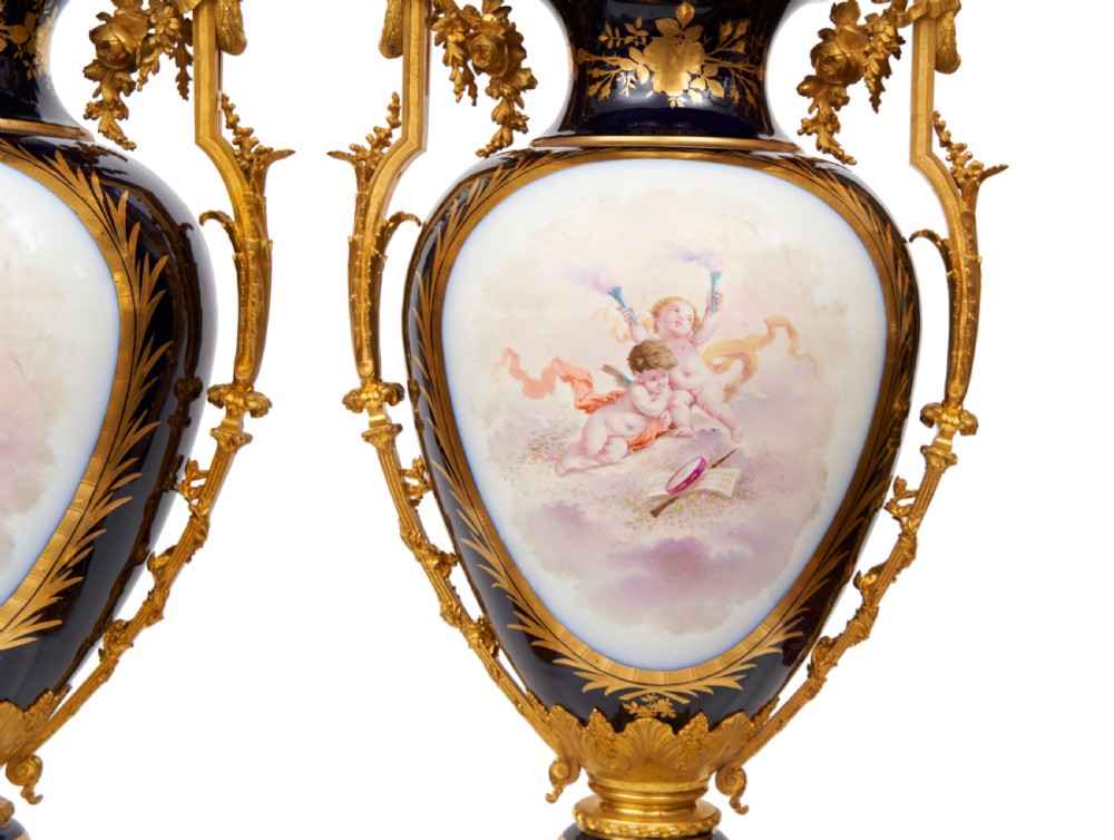 A pair of large French Sevres style cobalt blue porcelain lidded urns featuring hand-painted mythological scenes and elaborate gilded ormolu handles. View XVI