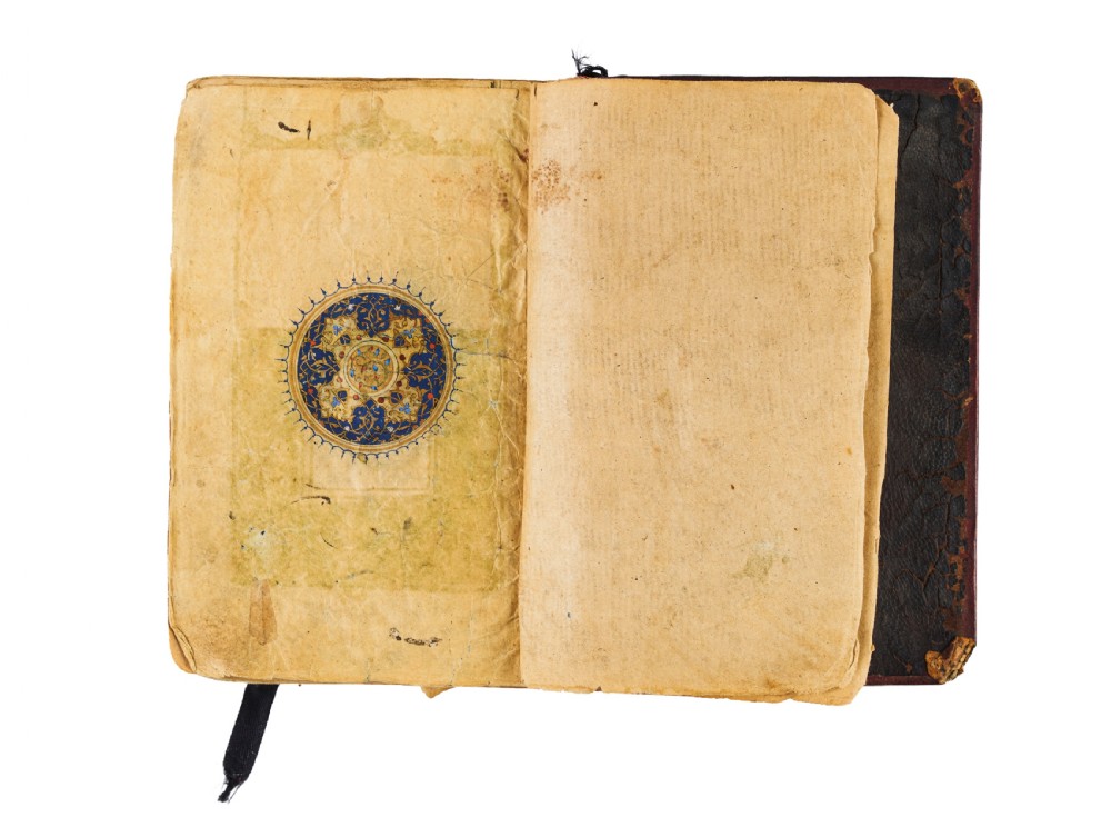 An open fifteenth-century Persian Timurid Quran manuscript featuring gold leaf and lapis lazuli blue arabesque illuminated frontispiece panels with Arabic calligraphy. View III