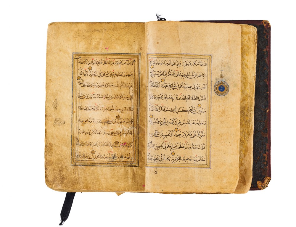 An open fifteenth-century Persian Timurid Quran manuscript featuring gold leaf and lapis lazuli blue arabesque illuminated frontispiece panels with Arabic calligraphy. View V