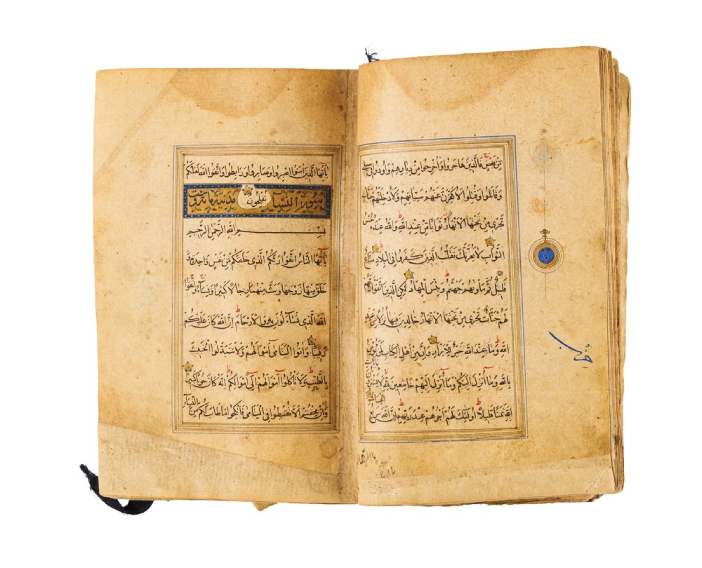 An open fifteenth-century Persian Timurid Quran manuscript featuring gold leaf and lapis lazuli blue arabesque illuminated frontispiece panels with Arabic calligraphy. View VI
