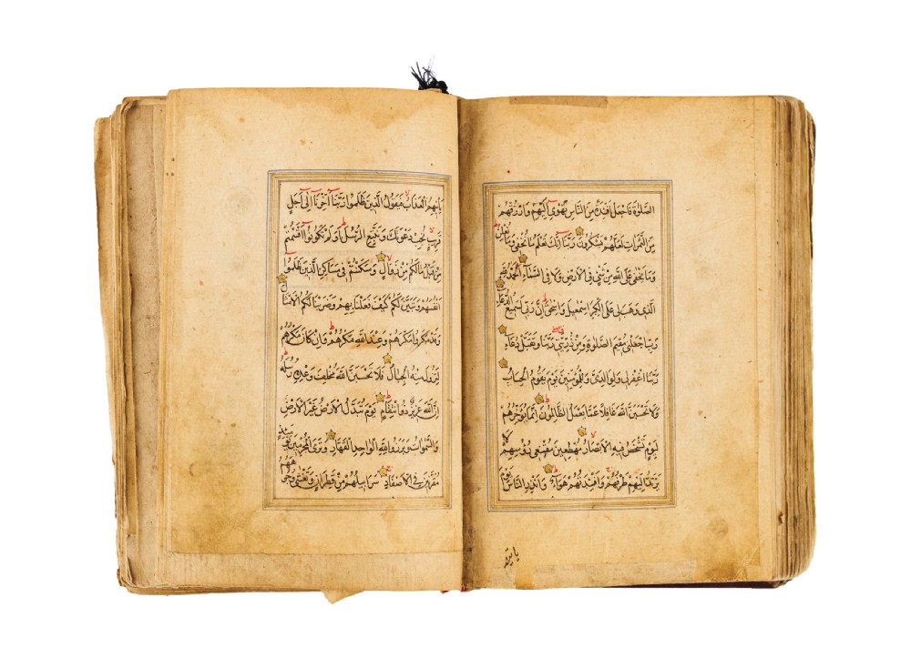 An open fifteenth-century Persian Timurid Quran manuscript featuring gold leaf and lapis lazuli blue arabesque illuminated frontispiece panels with Arabic calligraphy. View VII