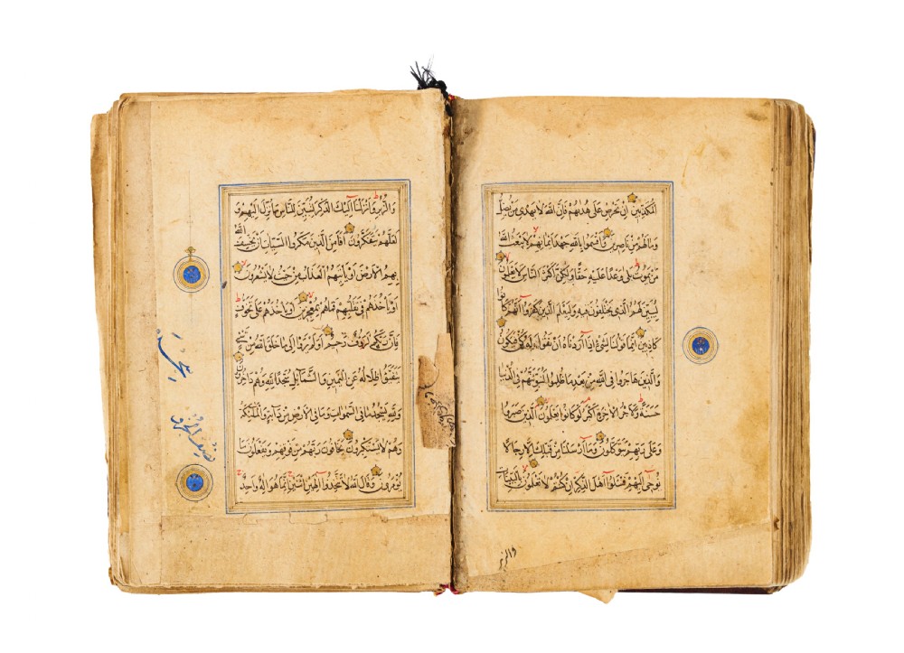 An open fifteenth-century Persian Timurid Quran manuscript featuring gold leaf and lapis lazuli blue arabesque illuminated frontispiece panels with Arabic calligraphy. View VIII
