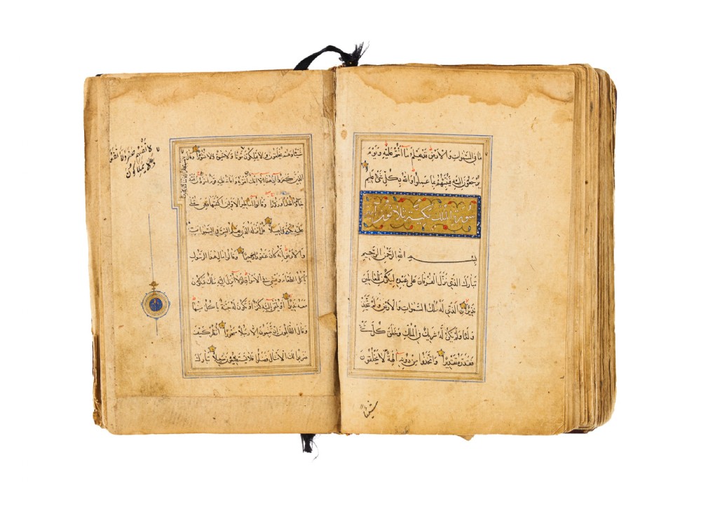 An open fifteenth-century Persian Timurid Quran manuscript featuring gold leaf and lapis lazuli blue arabesque illuminated frontispiece panels with Arabic calligraphy. View IX