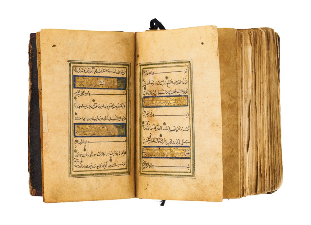 An open fifteenth-century Persian Timurid Quran manuscript featuring gold leaf and lapis lazuli blue arabesque illuminated frontispiece panels with Arabic calligraphy. View XII