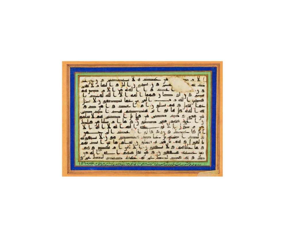 A rectangular vellum page featuring horizontal lines of dark Kufic Arabic script with small red dots, presented within a framed mount. View II