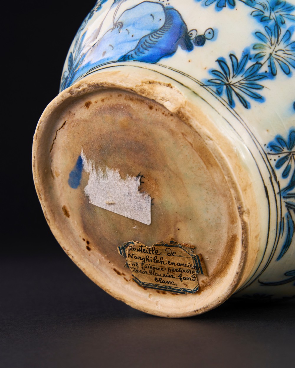 A 17th-century Safavid pottery kendi with blue underglaze painting depicting birds and foliage on a cream background. View III