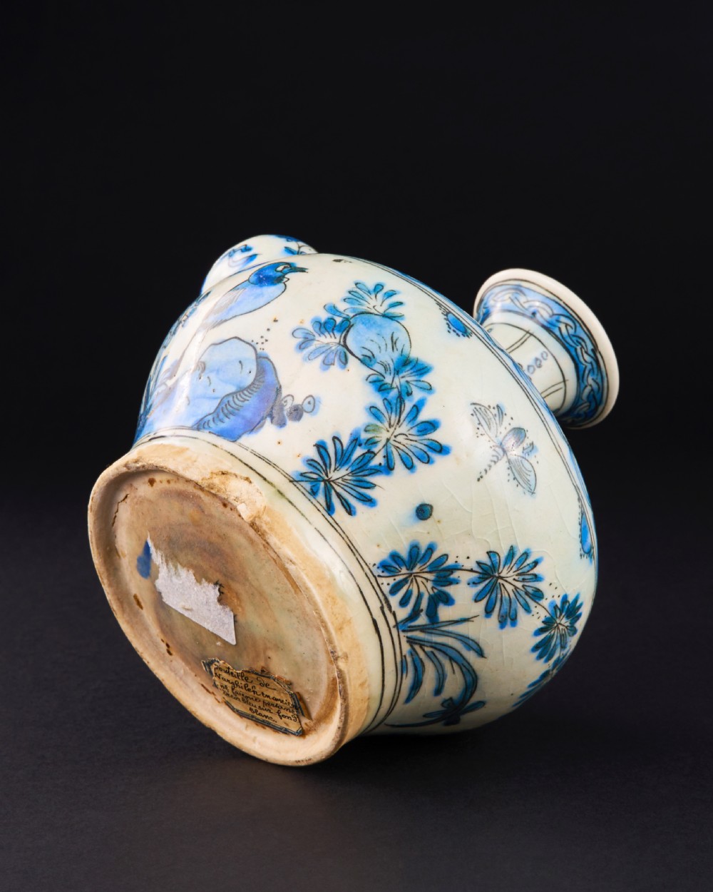 A 17th-century Safavid pottery kendi with blue underglaze painting depicting birds and foliage on a cream background. View IV