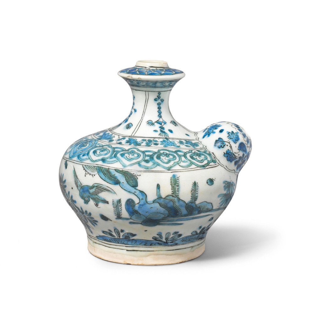 A 17th-century Safavid pottery kendi with blue underglaze painting depicting birds and foliage on a cream background. View V