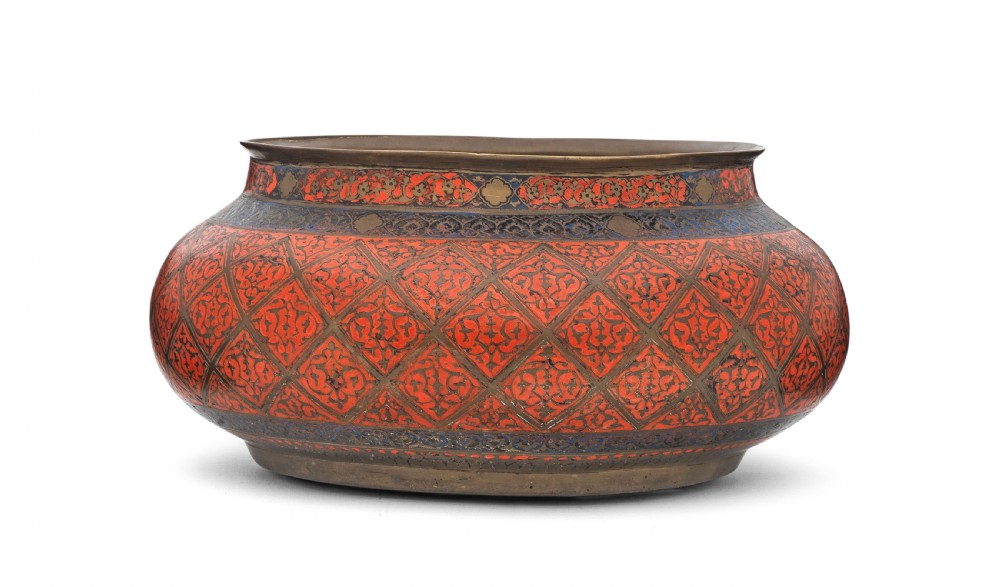 A bulbous Safavid period brass bowl featuring red and blue enamelled geometric lattice patterns around its body. View III