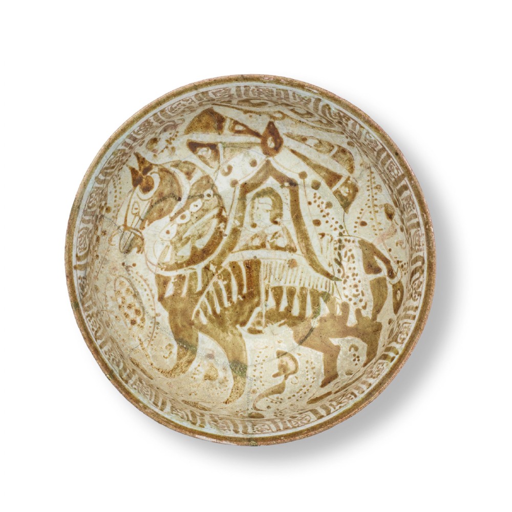 A rounded ceramic bowl featuring a painted central motif of a horse and rider surrounded by calligraphic borders in brown lustre against a cream background. View III