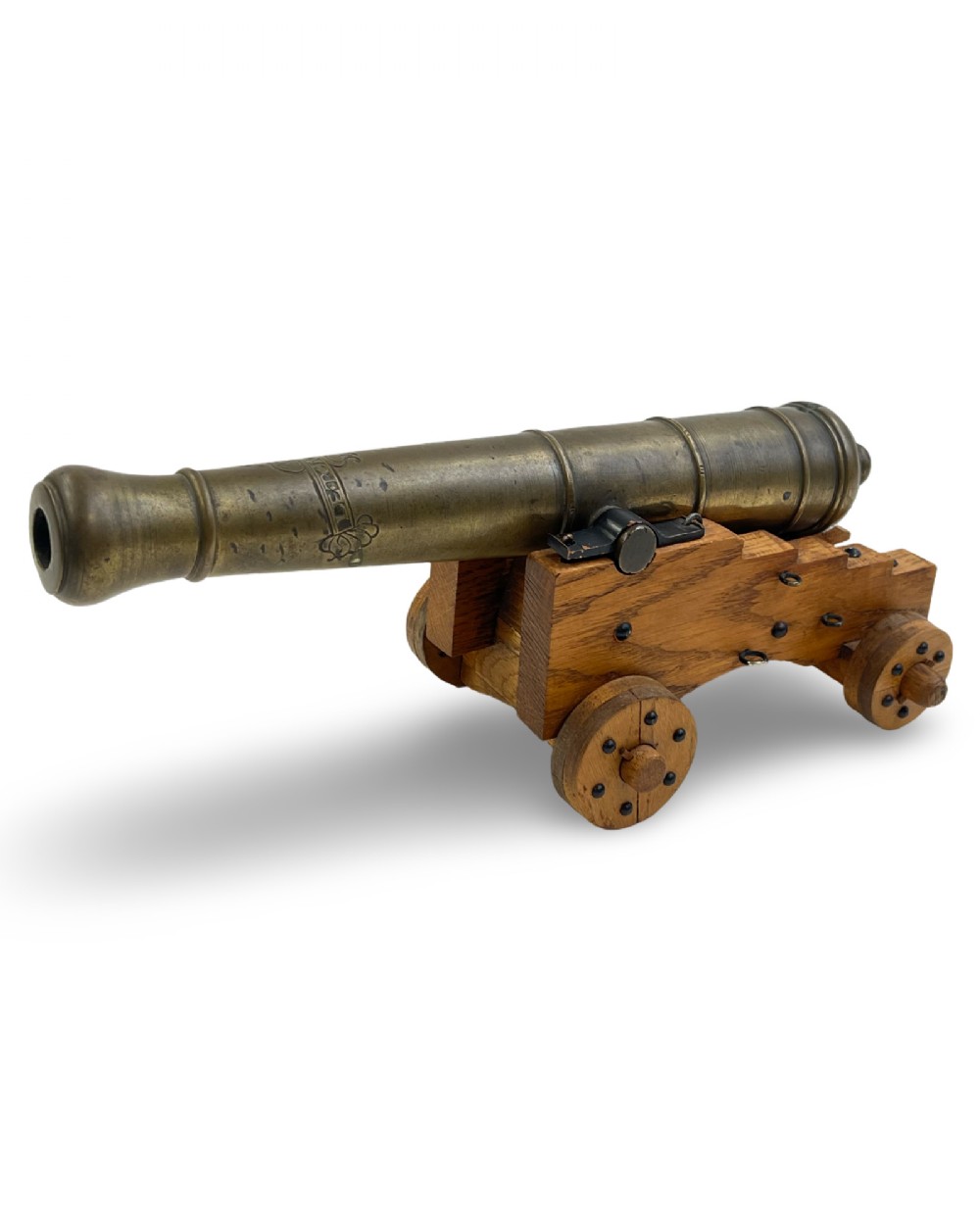 A small cast bronze signal cannon barrel with etched inscriptions mounted on a wooden stepped carriage with four wheels.