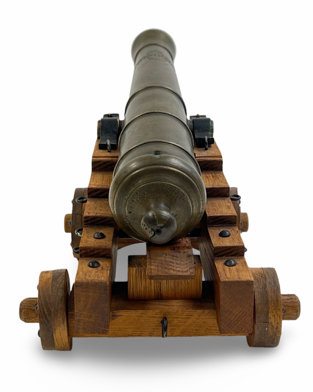 A small cast bronze signal cannon barrel with etched inscriptions mounted on a wooden stepped carriage with four wheels. View IV