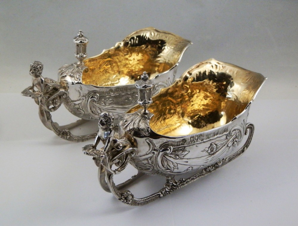 A pair of late Victorian sterling silver sleigh-shaped sauce boats with ornate rococo repousse detailing and gilded interiors. View II