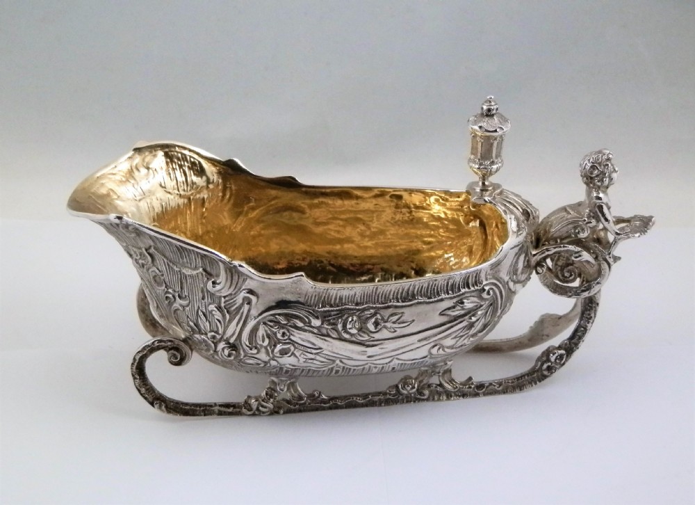 A pair of late Victorian sterling silver sleigh-shaped sauce boats with ornate rococo repousse detailing and gilded interiors. View V