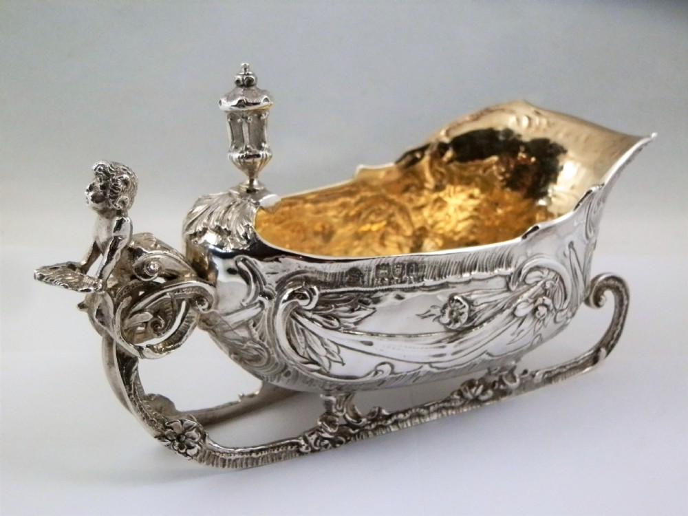 A pair of late Victorian sterling silver sleigh-shaped sauce boats with ornate rococo repousse detailing and gilded interiors. View VIII