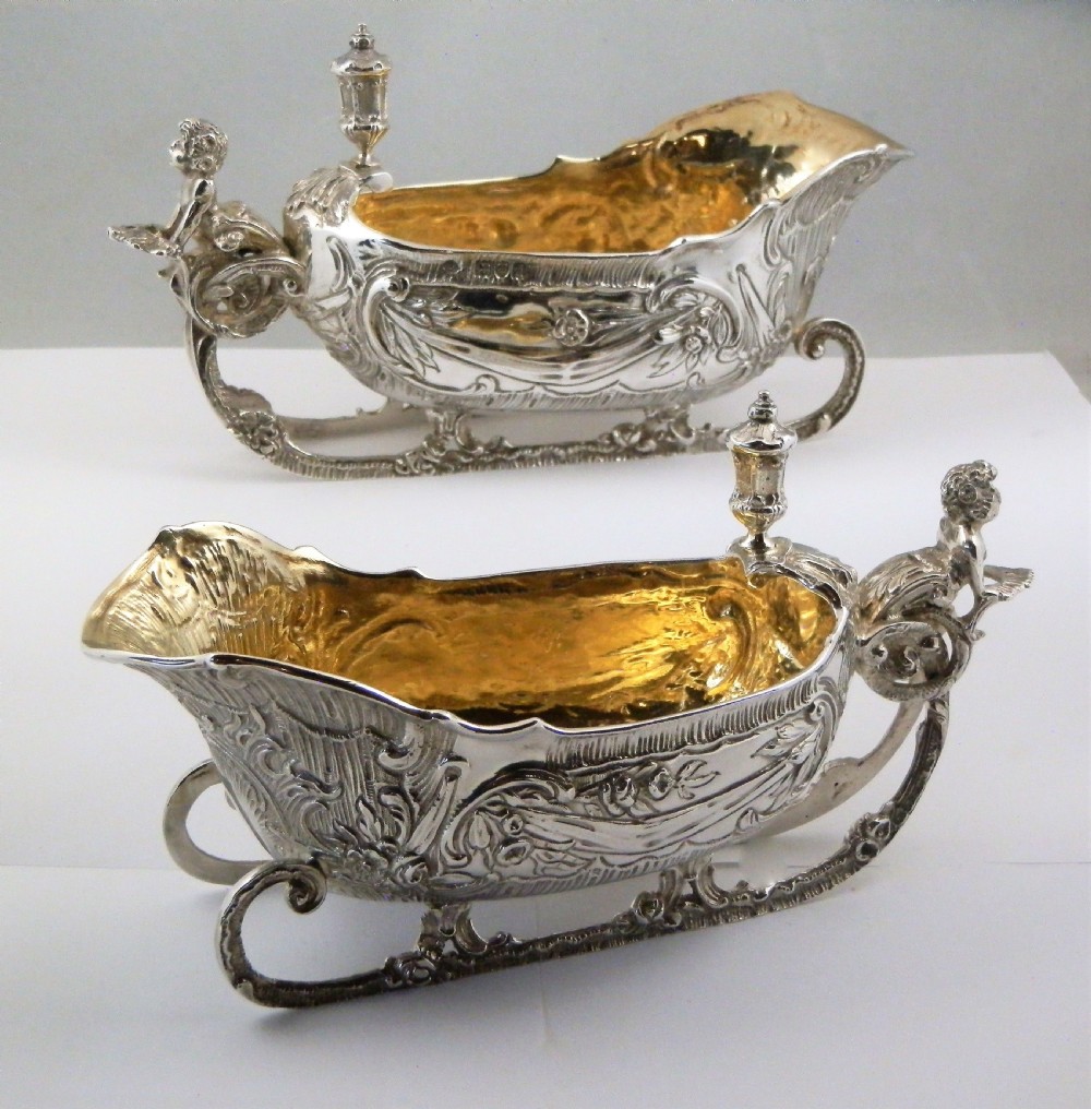 A pair of late Victorian sterling silver sleigh-shaped sauce boats with ornate rococo repousse detailing and gilded interiors. View XI