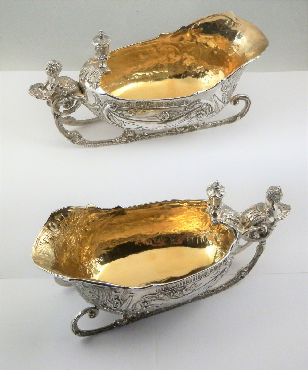 A pair of late Victorian sterling silver sleigh-shaped sauce boats with ornate rococo repousse detailing and gilded interiors. View XII