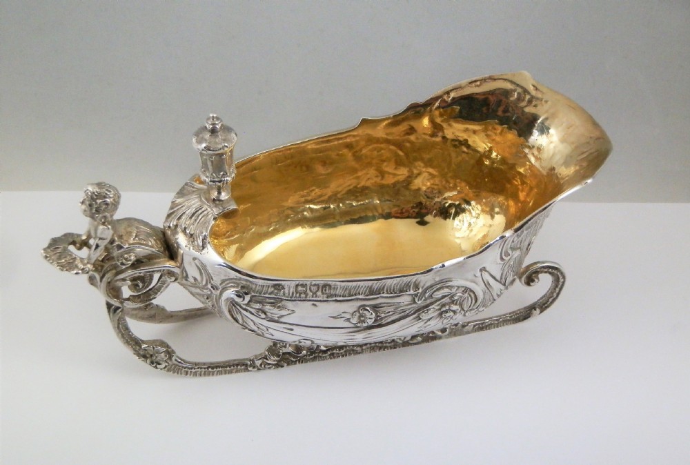 A pair of late Victorian sterling silver sleigh-shaped sauce boats with ornate rococo repousse detailing and gilded interiors. View XIII